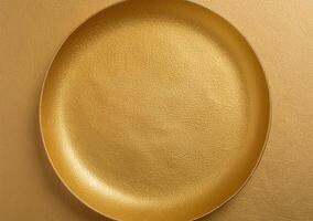 Top view of golden plate on gold background photo