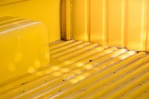 Yellow metal sheet on the back of the car,car surface on yellow metallic background and soft sunlight, charming vintage classic car. photo