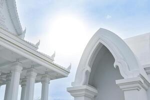 Pattaya, Thailand, August 7, 2023 - White temple and chapel architecture with beautiful Thai temple patterns in the sky and sunlight background. photo