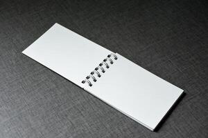 Two blank white notebooks on dark table wooden pattern background,Blank black cover template with copy space for design,notebook isolated on dark background, concept of design and business. photo