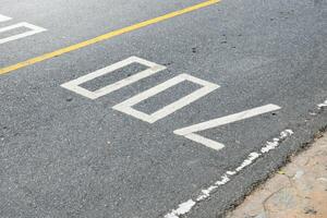 Road surface and yellow traffic lines with numbers seven hundred or 700 on soft sunlight background. photo