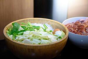 Various vegetables with egg in bowls and various marinated meats on black background used as an ingredient in Korea barbecue in thai style or pork grill for concept of healthy and foods. photo
