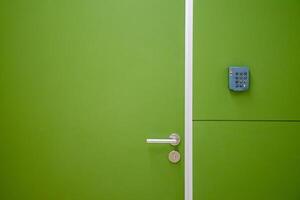 Close-up green door with coded door lock or code keypad on a soft green background and light for concept of Interior design and home safety. photo