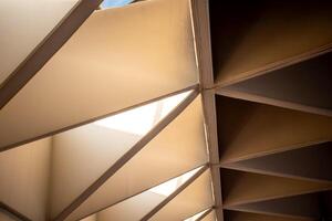 Modern abstract architecture and triangular concrete interior design decorating the ceiling of a modern building in warm colors tone. photo