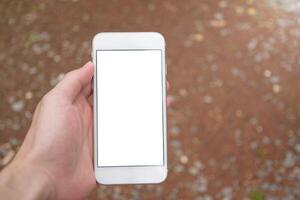 Man hand holding modern smartphone mockup with blank white screen in blurred background for concept of social media and marketing. photo