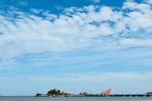 Chonburi, Thailand , August 5, 2023, Floating island Sriracha or Koh Loy is island floating in the middle of sea that has Thai temples with pagodas and shrines at outdoor park in blue sky background. photo