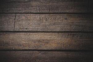 The surface of the brown wooden planks a beautiful natural wood pattern in a dark tone background. Close up the texture of wood is brown vintage for home design and decoration. photo