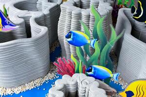 Artificial coral reef models and marine fish models are beautifully arranged to be used as props to simulate the ocean or sea for studying and learning about the nature under the sea. photo
