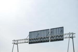 The back of a road or expressway sign showing the sign's steel structure over clear sky and sunlight background. photo