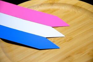 Colorful plastic name tags lined up on circular wooden plates have beautiful patterns on a dark background photo