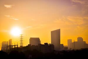 Panoramic view of the cityscape capital Bangkok with modern buildings and high voltage poles for transmitting electrical energy on the background of sunset sky warm tones in evening. photo