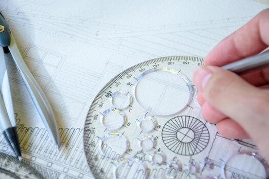 Selective focus of hand drawing line or sketching a house design or construction plan using a pencil and circle ruler on white paper with dividers for design and engineering concepts. photo