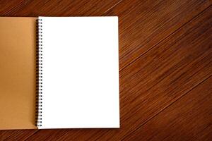 White blank page of notebook on brown wooden beautiful pattern background is a copyspec for the idea concept. Empty white blank notebook and paper texture background. photo