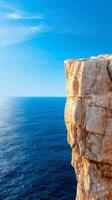 Majestic Cliff Edge Overlooking Blue Ocean with Clear Sky - Dramatic Coastal Landscape. photo