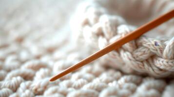 Beige Knitted Fabric With Wooden Knitting Needle In Soft Focus. photo
