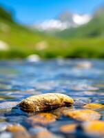 Close Up Of Smooth Rock In Tranquil River With Blurred Mountain Background. photo