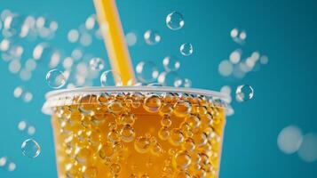 Sparkling Orange Juice With Straw In Disposable Cup And Bubbles On Turquoise Background. photo