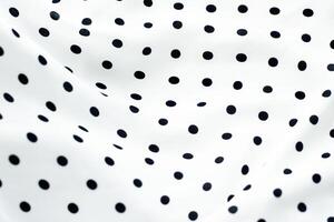 Classic polka dot textile background texture, black dots on white luxury fabric design pattern photo