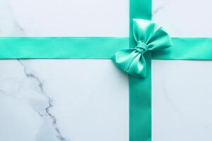 Green silk ribbon on marble background, top view photo