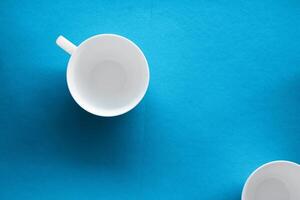 White tableware crockery set, empty cup on blue flatlay background photo