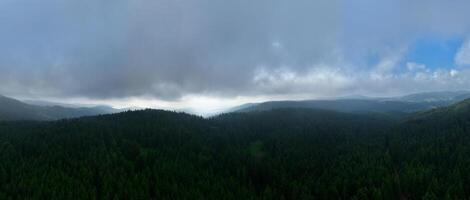 Aerial hyperlapse timelapse aerial view of clouds and mountains with green forest photo