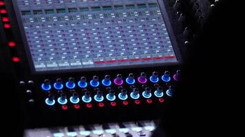 A sound engineer works at the sound console during a concert video