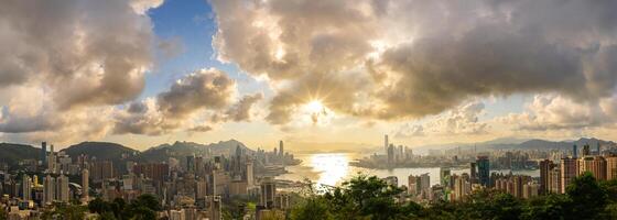 aerial view of Hong Kong skyline and cityscape with sunset. Amazing panorama of highrise buildings and modern towers and sky reflecting in the harbor. Hong Kong island and Kowloon landside. photo