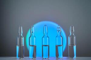 Several ampoules for injection with medicines on a blue background. photo