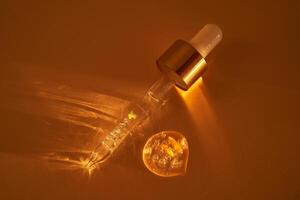 Pipette with serum shimmering in the sun on a beige background. photo