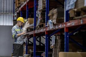 man worker walking and checking stock items for shipping. male inspecting the store factory. Logistics employees holding folders at on site warehouse area for shipping transportation. photo