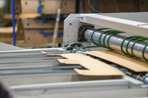 Cardboard on a machine production line, texture, background for graphics It is factory made cardboard waiting to be packed. photo