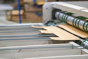 Cardboard on a machine production line, texture, background for graphics It is factory made cardboard waiting to be packed. photo