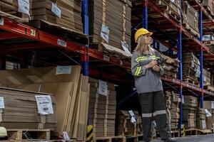 man worker walking and checking stock items for shipping. male inspecting the store factory. Logistics employees holding folders at on site warehouse area for shipping transportation. photo