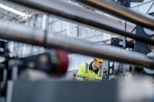 technician engineers checking the process on Heavy machine. mechanical engineering team production. Industry manufacturing. Worker holding tablet and folde. High technology production. photo
