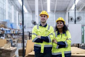 Male and female engineers in neat work clothes prepare and control the production system of large modern machines in a factory producing industrial technology products. photo