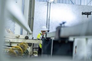 male engineers in neat work clothes prepare and control the production system of large modern machines in a factory producing industrial technology products. photo