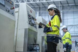 Male and female engineers in neat work clothes prepare and control the production system of large modern machines in a factory producing industrial technology products. photo