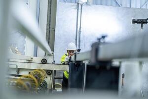 male engineers in neat work clothes prepare and control the production system of large modern machines in a factory producing industrial technology products. photo