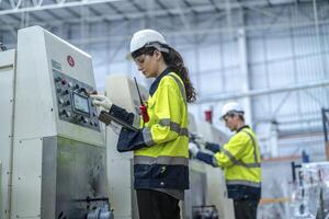 Male and female engineers in neat work clothes prepare and control the production system of large modern machines in a factory producing industrial technology products. photo