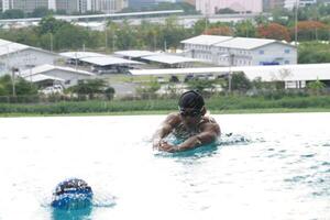 Asian men practicing swimming and preparing to play water polo and stretching and resting for water sports. photo