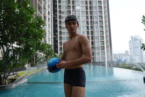 Asian men practicing swimming and preparing to play water polo and stretching and resting for water sports. photo