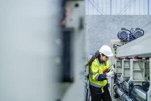 female engineers in neat work clothes prepare and control the production system of large modern machines in a factory producing industrial technology products. photo