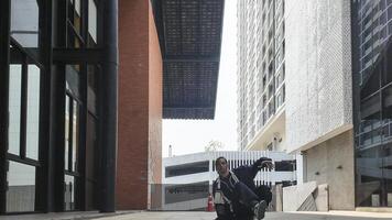 ASian man is dancing in hip hop style at outdoor space. Professional solo dancer is performing in public area. photo