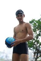 Asian men practicing swimming and preparing to play water polo and stretching and resting for water sports. photo