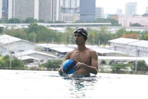 Asian men practicing swimming and preparing to play water polo and stretching and resting for water sports. photo