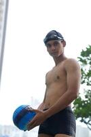 Asian men practicing swimming and preparing to play water polo and stretching and resting for water sports. photo