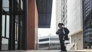 ASian man is dancing in hip hop style at outdoor space. Professional solo dancer is performing in public area. photo