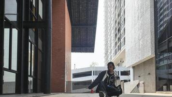 ASian man is dancing in hip hop style at outdoor space. Professional solo dancer is performing in public area. photo