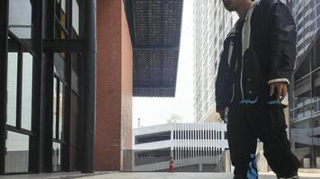 ASian man is dancing in hip hop style at outdoor space. Professional solo dancer is performing in public area. photo