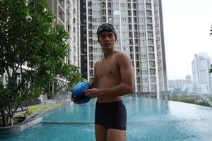 Asian men practicing swimming and preparing to play water polo and stretching and resting for water sports. photo